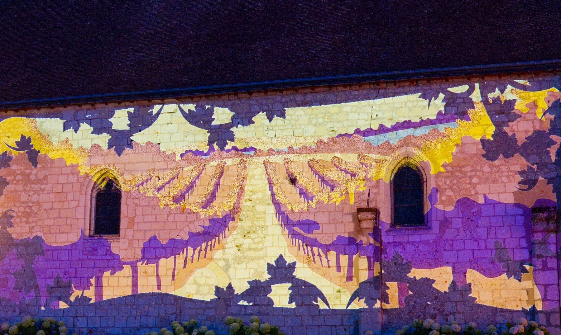Paysage de vignes en perspective projeté sur le mur de l'église de Mareuil-sur-Cher