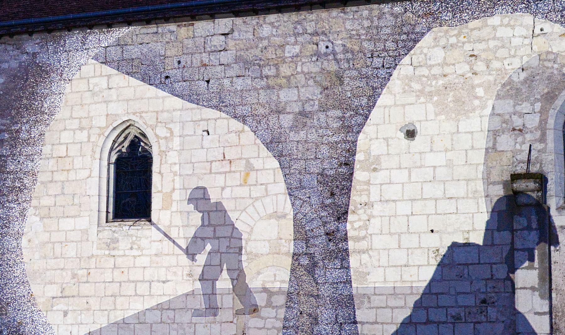Silhouettes de vignerons au travail projetées sur la façade